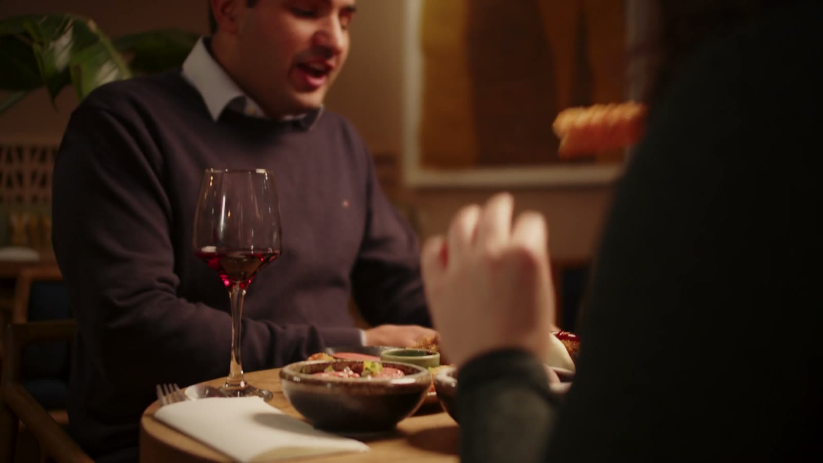 Wine being poured at a candlelit restaurant table