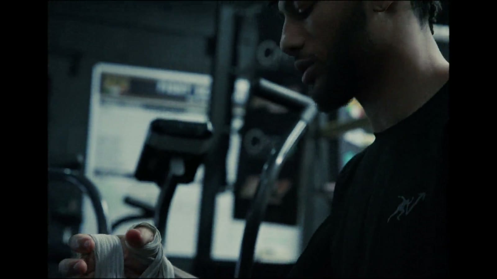 A fighter working the bag in a dark, neon-lit boxing gym